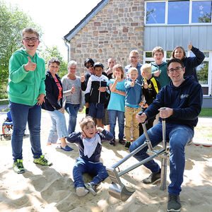 Gruppenfoto: Kinder im Sandkasten mit dem Sandbagger