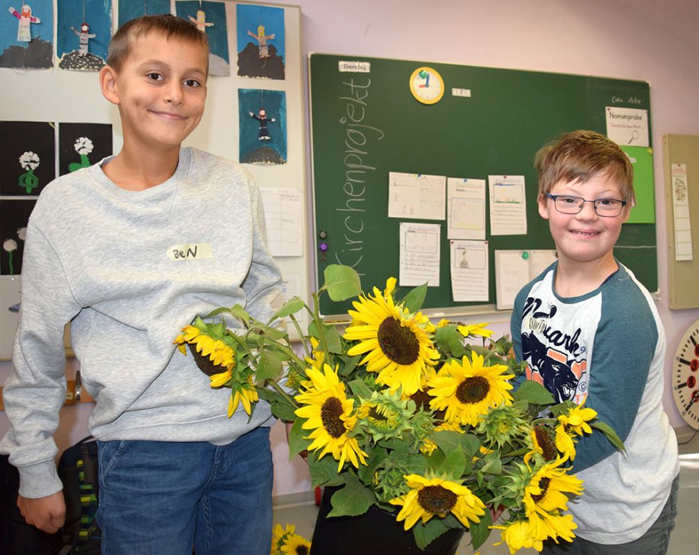 Gruppenfoto: Zwei Jungen vor einer Schultafel