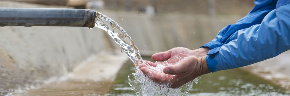 Eine Hand unter einer sprudelnden Heilwasserquelle